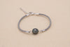 Bracelet en coton de couleur gris avec une perle de tahiti ovale