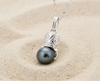 Pendentif en argent 925 avec un tiki qui enlace une perle de Tahiti sur du sable