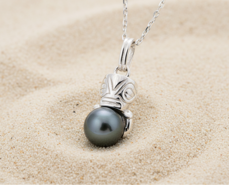 Pendentif en argent 925 avec un tiki qui enlace une perle de Tahiti sur du sable