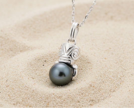 Pendentif en argent 925 avec un tiki qui enlace une perle de Tahiti sur du sable